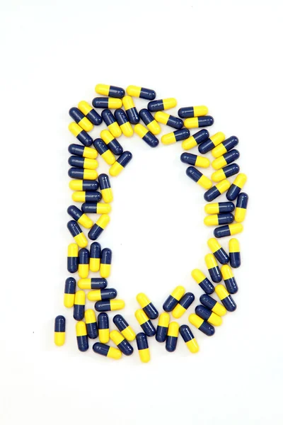 Алфавіт літери D, зроблений з медичних капсул — стокове фото