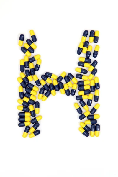 Алфавіт літери H, зроблений з медичних капсул — стокове фото