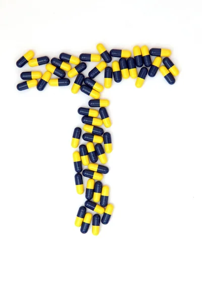 The letter T alphabet made of medical capsules — Stock Photo, Image