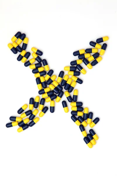 De letter x alfabet gemaakt van medische capsules — Stockfoto
