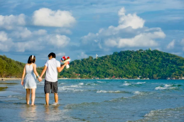 甜蜜情侣的手牵手在沙滩散步与轻质 — 图库照片
