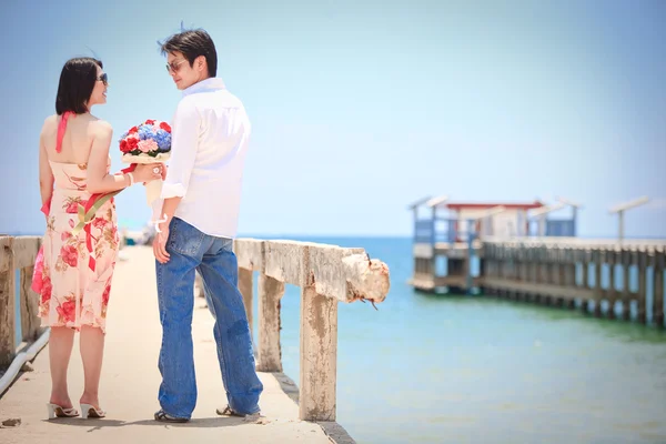 Par få ögonkontakt vid pier på stranden — Stockfoto