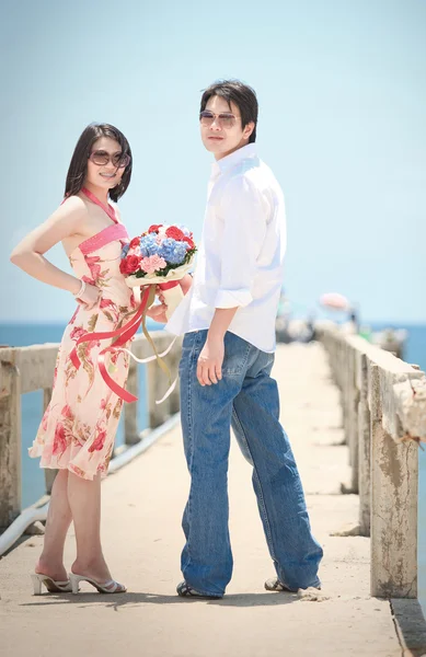 Porträtt av par på pier på stranden — Stockfoto