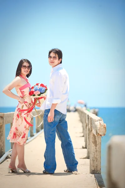Porträtt av par på pier på stranden — Stockfoto