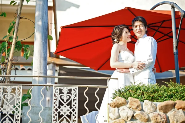 Retrato de noiva romântica e noivo com guarda-chuva vermelho — Fotografia de Stock