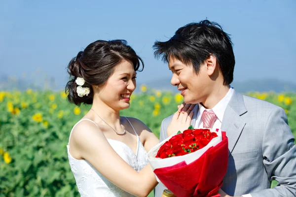 stock image Portrait of bride and groom seeing each other on sunflower field