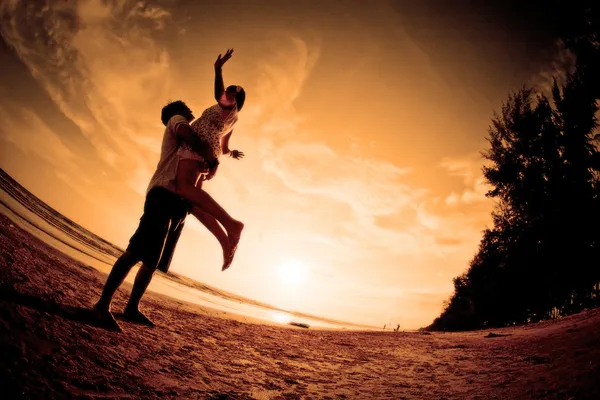 夫妇在海滩上的浪漫场景 免版税图库图片