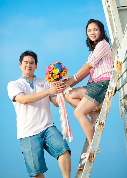 Güzel holding çiftler birlikte sahilde buket çiçekler — Stok fotoğraf