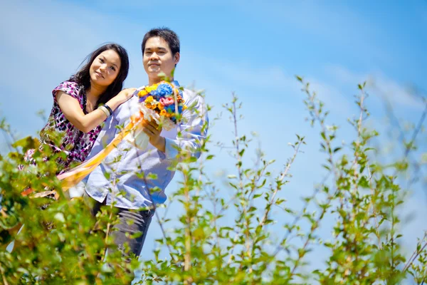 Coppie romantiche in piedi all'aperto con mazzo di fiori — Foto Stock