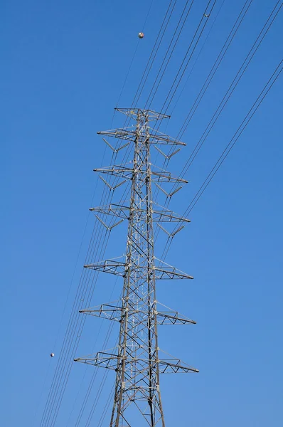 Electrical tower in field under blue sky — Stock Photo, Image
