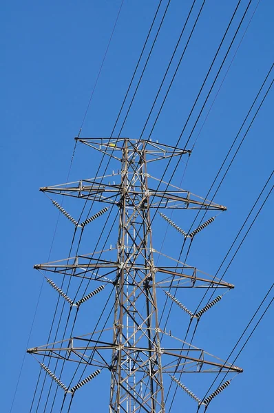 Torre eléctrica en campo bajo cielo azul —  Fotos de Stock