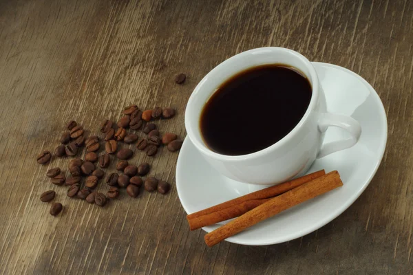 Coffee cup with beans and cinnamon sticks — Stock Photo, Image