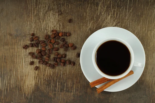 Šálek kávy s fazolemi a skořicovými tyčinkami — Stock fotografie