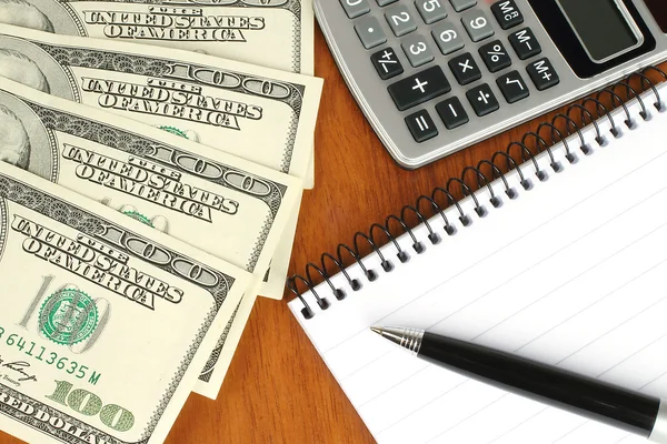 Pengar, kalkylator, anteckningsblock och penna — Stockfoto