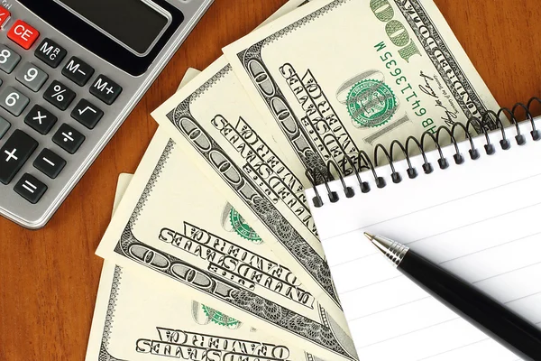 Деньги, калькулятор, блокнот и ручка — стоковое фото