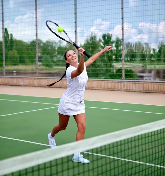 Jonge vrouw op een tennisbaan — Stockfoto