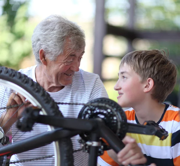 Grootvader en kleinzoon van een fiets reparatie — Stockfoto