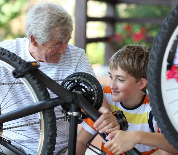 Grootvader en kleinzoon van een fiets reparatie — Stockfoto