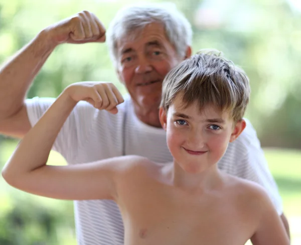 Dědeček a vnuk protahuje biceps — Stock fotografie
