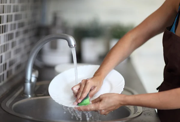 Cleaning dishware kitchen sink sponge washing dish — Stock Photo, Image