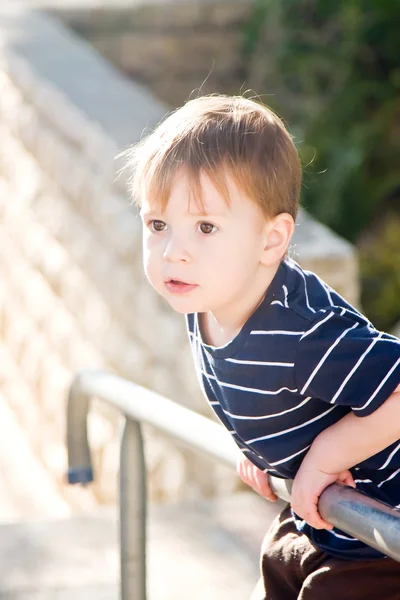 Маленький хлопчик на паркані — стокове фото