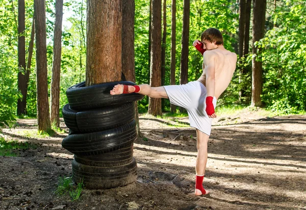 Combatiente pateando ruedas de goma con la pierna — Foto de Stock