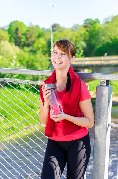 水のボトルと女性ランナーの笑顔 — ストック写真