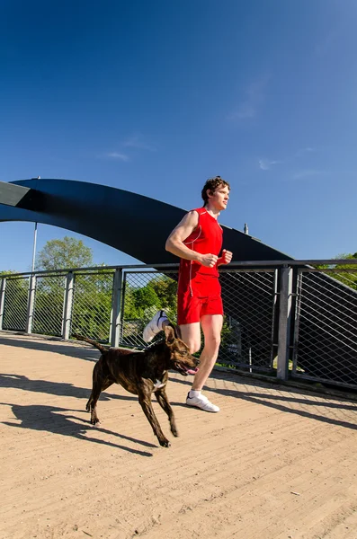 Sportovec a pes běží venku — Stock fotografie