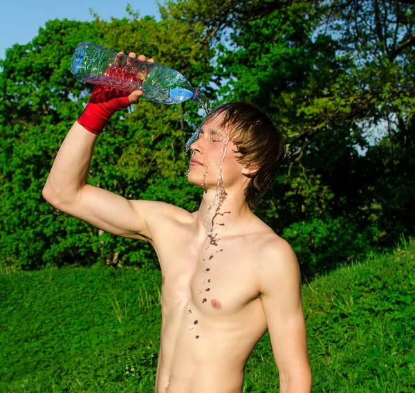 Müder Sportler gießt sich Wasser auf den Kopf. — Stockfoto