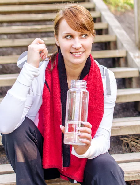水のボトルと女性ランナーの笑顔 — ストック写真