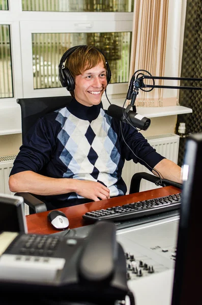 Anchorman sitter framför en mikrofon på radion — Stockfoto