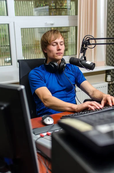 Dj trabalhando na frente de um microfone no rádio — Fotografia de Stock