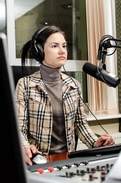Anchorwoman sentada frente a un micrófono en la radio — Foto de Stock