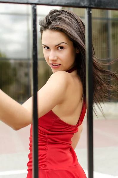 Schöne Mädchen in rotem Kleid posiert auf der Straße — Stockfoto