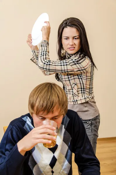 Domestic violence: Wife trying to beat her husband with a plate — Stock Photo, Image