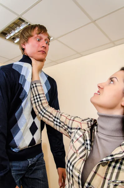 Борьба в офисе: женщина пытается задушить мужчину — стоковое фото
