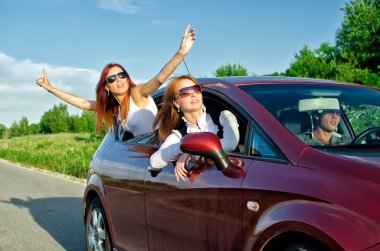 Two pretty happy girls in the car. Concept of carefree roadtrip clipart