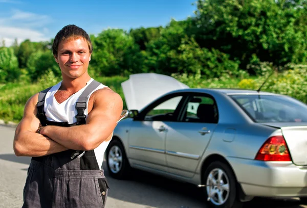 Handsome mechanic on a road near the broken car. — Stock Photo, Image