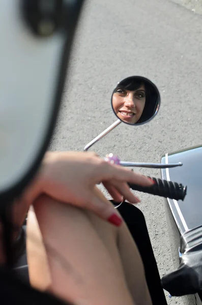 Hübsche Frau spiegelt sich im Motorradspiegel. — Stockfoto