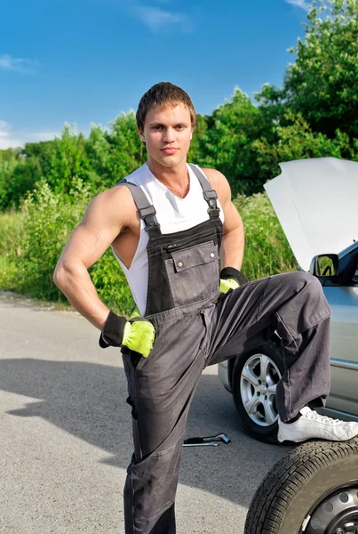 Retrato de un mecánico guapo en una carretera — Foto de Stock