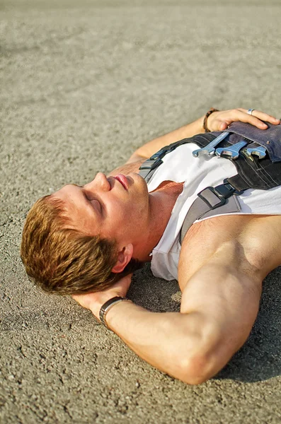 Tired mechanic resting on the road — Stock Photo, Image