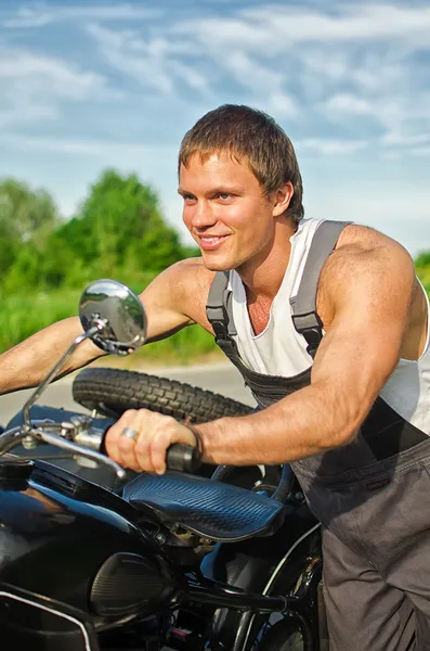 Retrato del mecánico guapo empujando una motocicleta — Foto de Stock