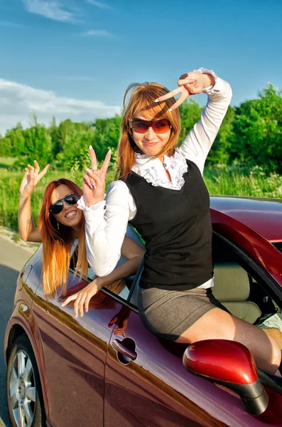 Zwei ziemlich glückliche Mädchen im Auto. Konzept des unbeschwerten Roadtrips — Stockfoto