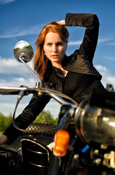 Rothaarige Mädchen posieren auf einem Retro-Motorrad — Stockfoto