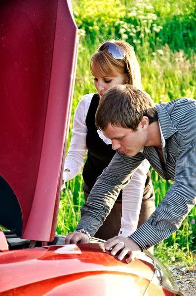 Man and woman are looking at the car engine — Stock Photo, Image