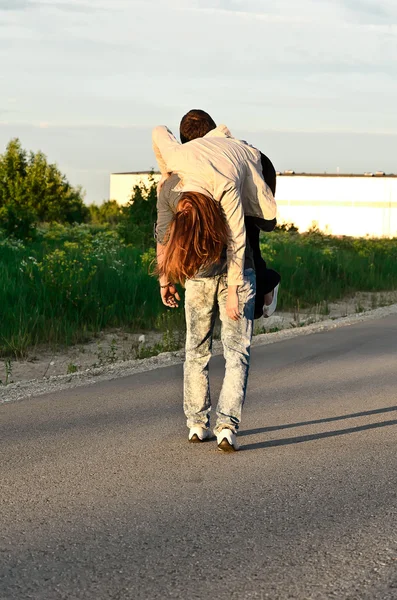 Uomo che porta una giovane donna sulla spalla . — Foto Stock