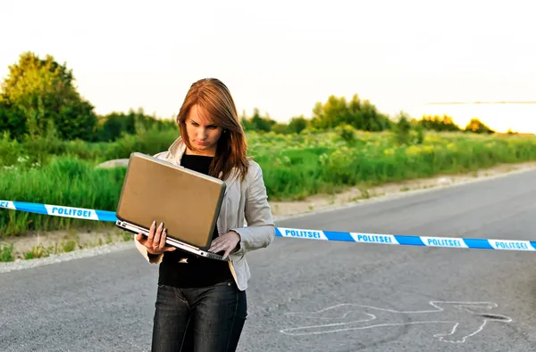 Young criminalist with laptop on a crime scene — Stock Photo, Image