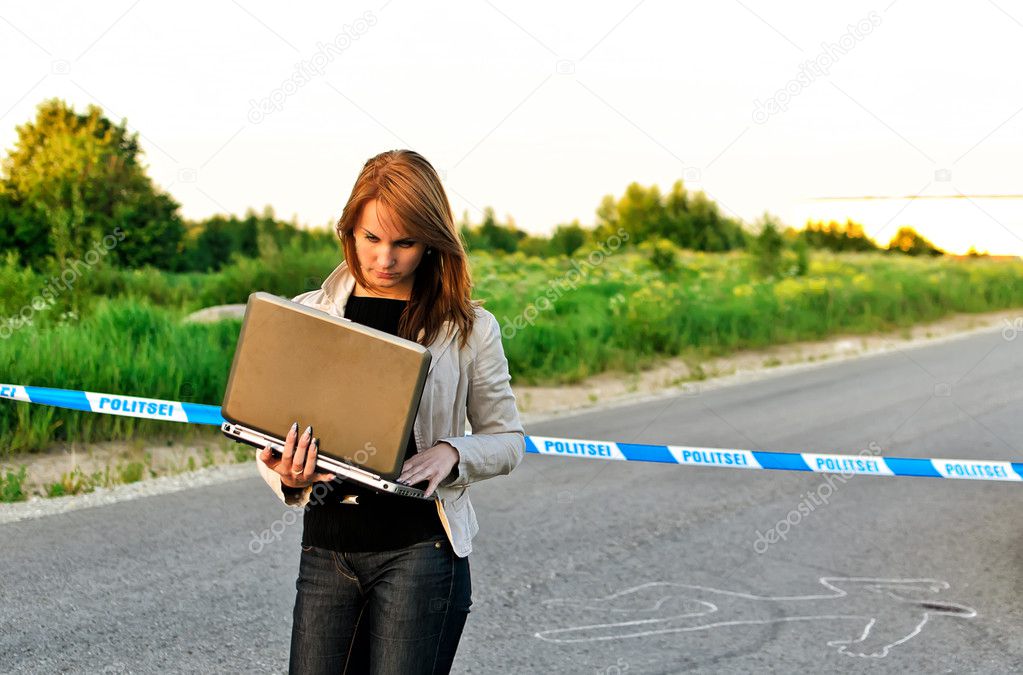 Young criminalist with laptop on a crime scene