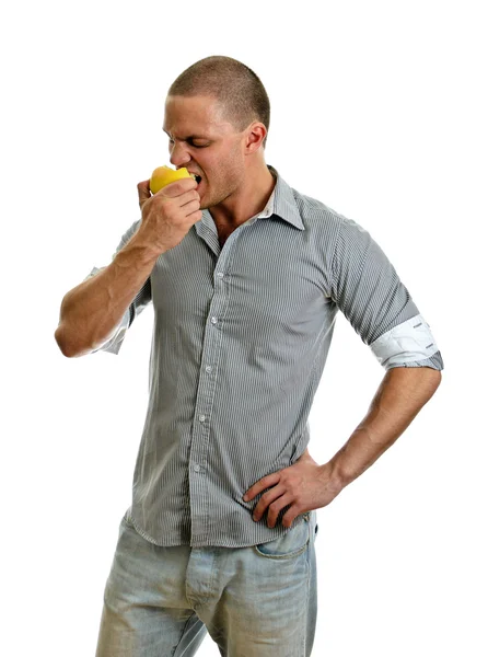 Un uomo che mangia una mela. Isolato su bianco . — Foto Stock