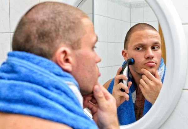 鏡の前に浴室にタオル シェービングを持つ男性. — ストック写真